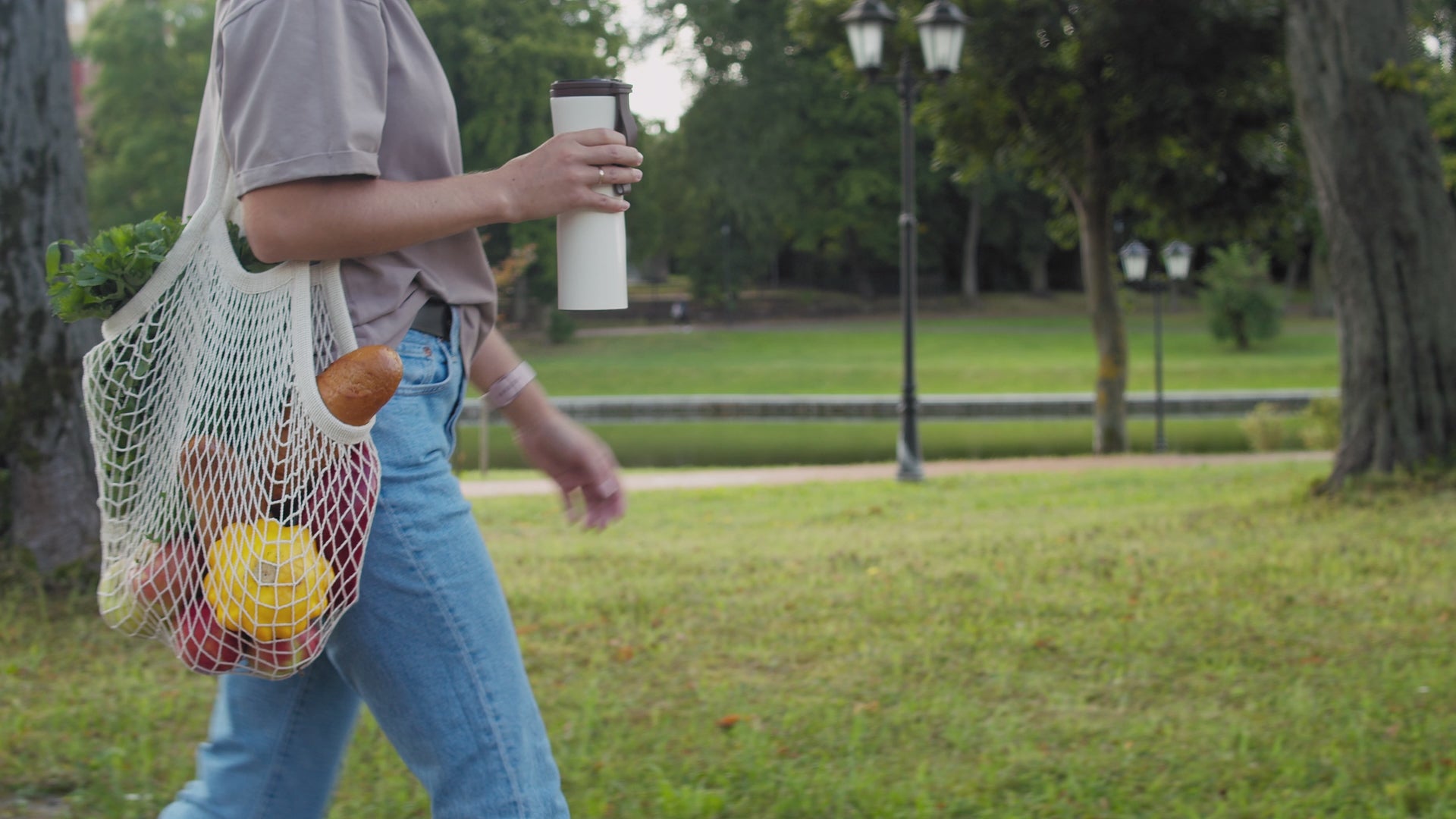 Video of a woman walking outside with a natural colored string bag