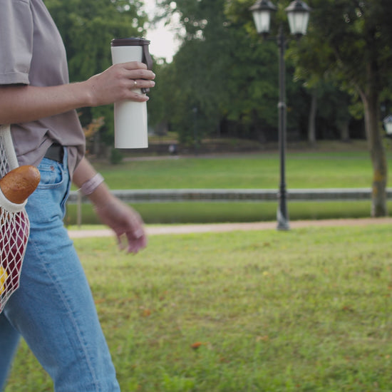 Video of a woman walking outside with a natural colored string bag