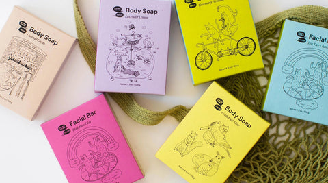 Meow Meow Tweet soap, shampoo, and conditioner bars are flat laid against an Olive ECOBAGS String bag