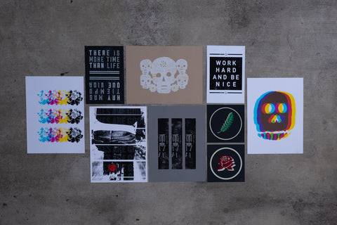 An array of art prints from Ramona Press are arranged in a flat lay on concrete